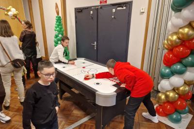 Un bus stationné de nuit devant un bâtiment illuminé, avec des passants en arrière-plan.