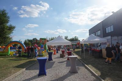 Un bus stationné de nuit devant un bâtiment illuminé, avec des passants en arrière-plan.