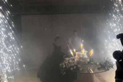 Un bus stationné de nuit devant un bâtiment illuminé, avec des passants en arrière-plan.