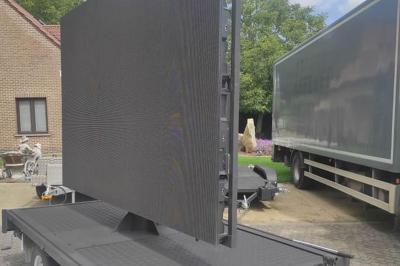 Un bus stationné de nuit devant un bâtiment illuminé, avec des passants en arrière-plan.