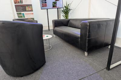 Un bus stationné de nuit devant un bâtiment illuminé, avec des passants en arrière-plan.