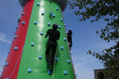 Un bus stationné de nuit devant un bâtiment illuminé, avec des passants en arrière-plan.