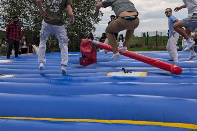 Un bus stationné de nuit devant un bâtiment illuminé, avec des passants en arrière-plan.
