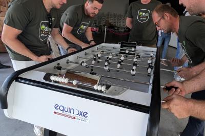 Un bus stationné de nuit devant un bâtiment illuminé, avec des passants en arrière-plan.
