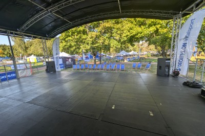 Un bus stationné de nuit devant un bâtiment illuminé, avec des passants en arrière-plan.