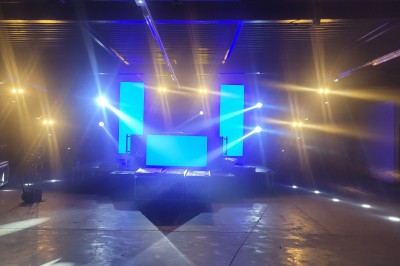 Miniature Equinoxe #160 Un bus stationné de nuit devant un bâtiment illuminé, avec des passants en arrière-plan.