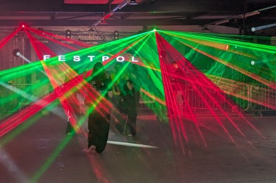 Miniature Equinoxe #61 Un bus stationné de nuit devant un bâtiment illuminé, avec des passants en arrière-plan.