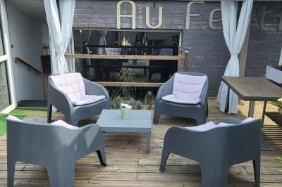 Miniature Location salle Mouscron (Hainaut) - Au Festival de Mouscron  #62 Terrasse en bois avec fauteuils, pergola à rideaux blancs, plantes en pot et mur en briques en arrière-plan.