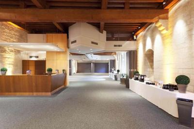 Vue nocturne d'un jardin avec des invités rassemblés lors d'un événement, éclairé par des lumières chaleureuses.