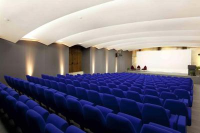 Vue nocturne d'un jardin avec des invités rassemblés lors d'un événement, éclairé par des lumières chaleureuses.