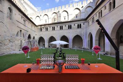 Vue nocturne d'un jardin avec des invités rassemblés lors d'un événement, éclairé par des lumières chaleureuses.