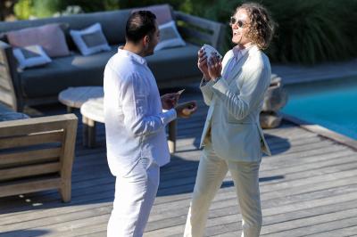 Miniature Robin Geyer - Magicien Professionnel Français #4 Un homme en costume parle avec animation à une femme souriante dans un café, entourés de mains applaudissant.