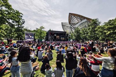 Miniature Robin Geyer - Magicien Professionnel Français #5 Deux femmes en robes rouges scintillantes lèvent les bras en souriant, entourées d'étincelles et de fumée.