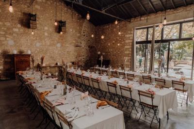 Chambre lumineuse avec lit double, fauteuil beige, fenêtre ouverte sur un paysage et décoration murale en osier.