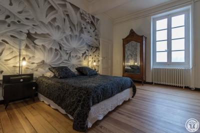 Piscine rectangulaire entourée de dalles et pelouse, avec un grand arbre en arrière-plan sous un ciel dégagé.