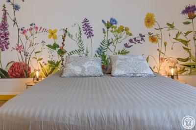 Piscine rectangulaire entourée de dalles et pelouse, avec un grand arbre en arrière-plan sous un ciel dégagé.