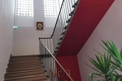 Piscine rectangulaire entourée de dalles et pelouse, avec un grand arbre en arrière-plan sous un ciel dégagé.
