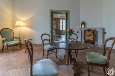 Piscine rectangulaire entourée de dalles et pelouse, avec un grand arbre en arrière-plan sous un ciel dégagé.