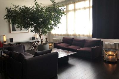 Miniature Location salle Paris 20 (Paris) - Studio 7 #13 Salle avec des tables et chaises noires disposées en U, projection d’un paon coloré sur un mur blanc, rideaux noirs à droite.