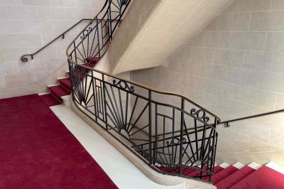 Miniature Location salle Paris 20 (Paris) - Studio 7 #17 Salle avec des tables et chaises noires disposées en U, projection d’un paon coloré sur un mur blanc, rideaux noirs à droite.