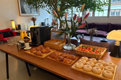 Miniature Location salle Paris 20 (Paris) - Studio 7 #10 Salle avec des tables et chaises noires disposées en U, projection d’un paon coloré sur un mur blanc, rideaux noirs à droite.