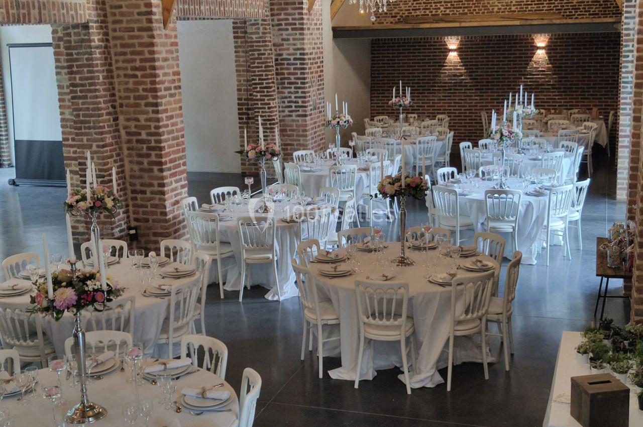 Location salle Haverskerque (Nord) - Ferme d'Hercule #3 Salle de réception avec tables rondes dressées, nappes blanches, chandeliers et décorations florales.