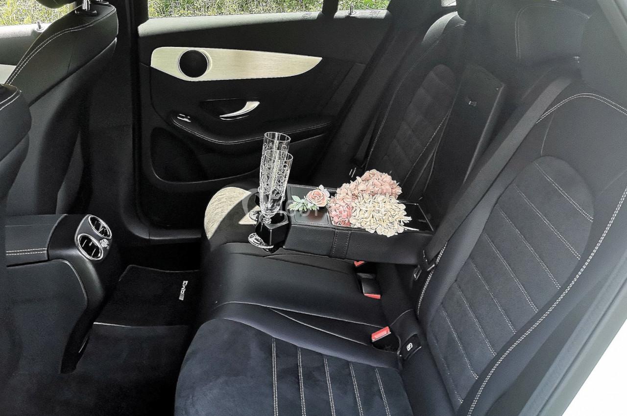 Photo David J. Location #12 Intérieur d'une voiture avec des sièges en cuir noir, un bouquet de fleurs et deux flûtes à champagne posés à l'arrière.