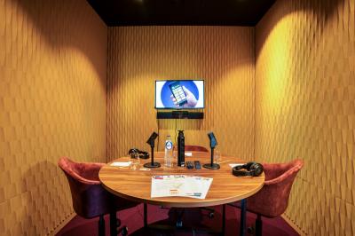 Vue aérienne d'un parking vide entouré de végétation, avec quelques voitures stationnées et un ciel dégagé.