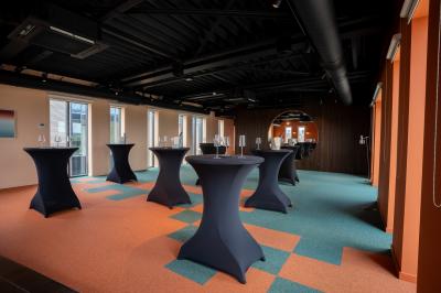 Vue aérienne d'un parking vide entouré de végétation, avec quelques voitures stationnées et un ciel dégagé.