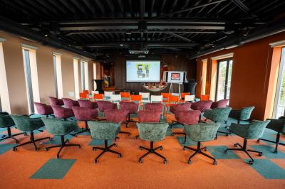 Vue aérienne d'un parking vide entouré de végétation, avec quelques voitures stationnées et un ciel dégagé.