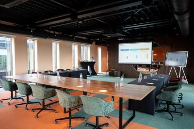 Vue aérienne d'un parking vide entouré de végétation, avec quelques voitures stationnées et un ciel dégagé.