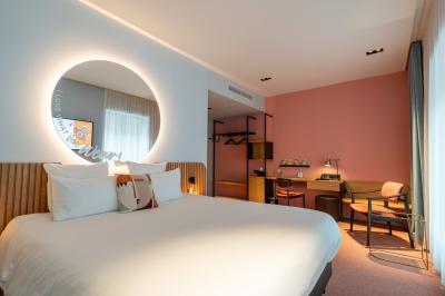 Vue aérienne d'un parking vide entouré de végétation, avec quelques voitures stationnées et un ciel dégagé.