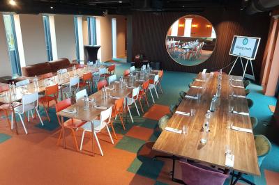 Vue aérienne d'un parking vide entouré de végétation, avec quelques voitures stationnées et un ciel dégagé.