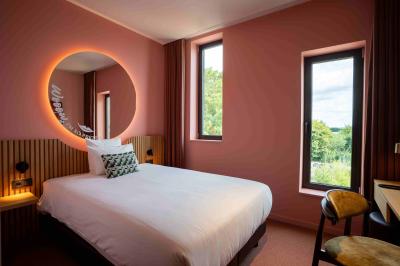 Vue aérienne d'un parking vide entouré de végétation, avec quelques voitures stationnées et un ciel dégagé.