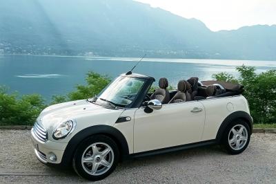 Six voitures blanches et noires alignées sur un parking, disponibles pour des locations de courte durée.