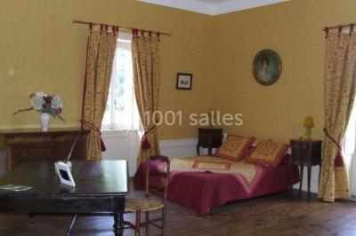 Salle de restaurant avec tables rondes dressées, nappes blanches, chaises en bois et éclairage tamisé.
