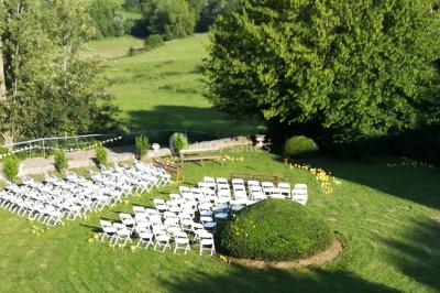Salle de restaurant avec tables rondes dressées, nappes blanches, chaises en bois et éclairage tamisé.