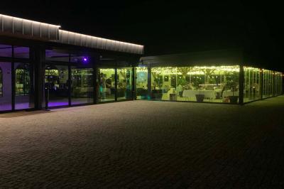 Miniature Location salle Cleppé (Loire) - L'Orangerie de Châtel #34 Un grand arbre illuminé en vert avec des guirlandes lumineuses, près d'un bâtiment éclairé, de nuit.