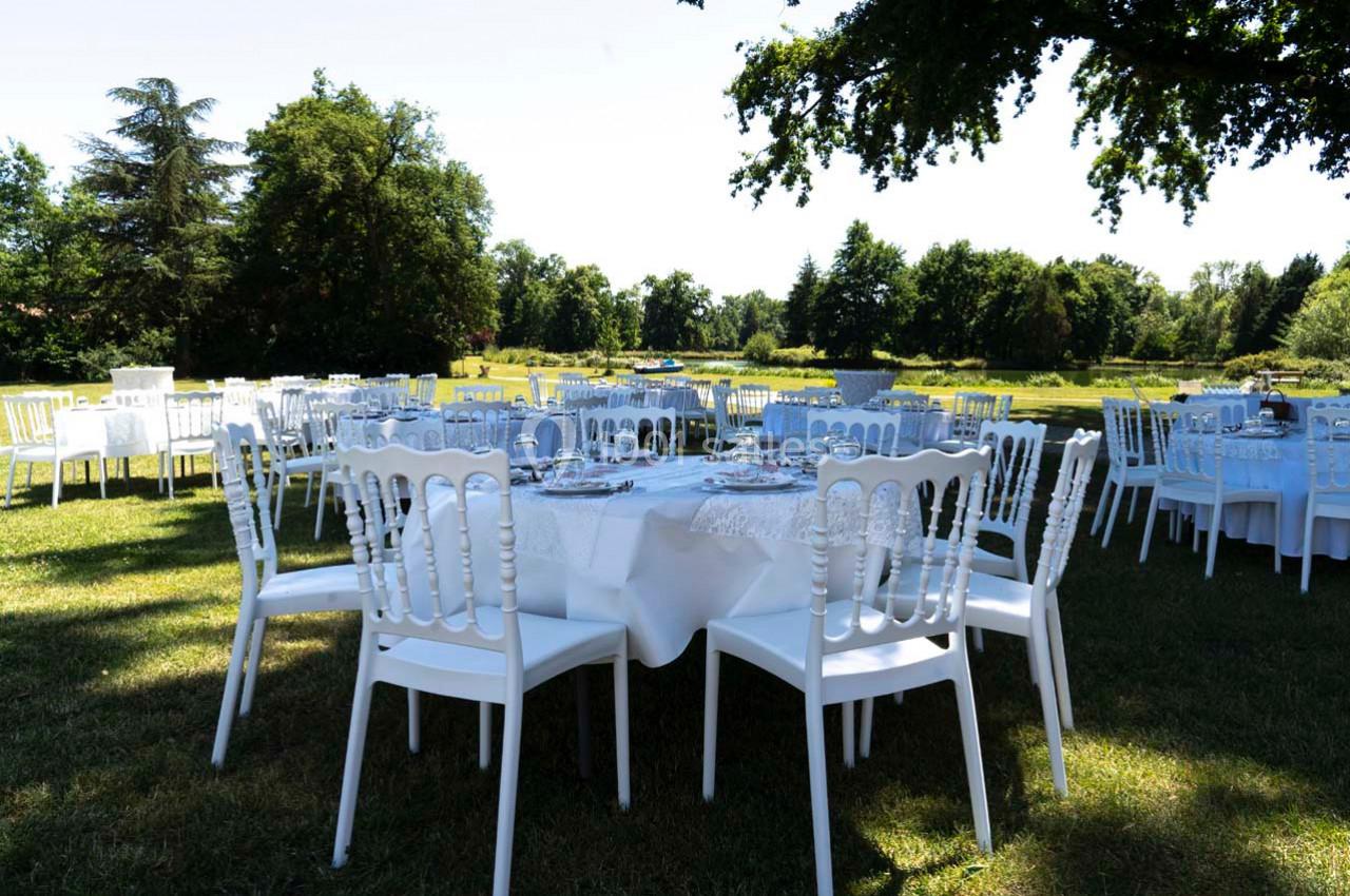 Location salle Cleppé (Loire) - L'Orangerie de Châtel #9 Tables dressées avec nappes blanches et chaises blanches disposées en extérieur dans un parc verdoyant.