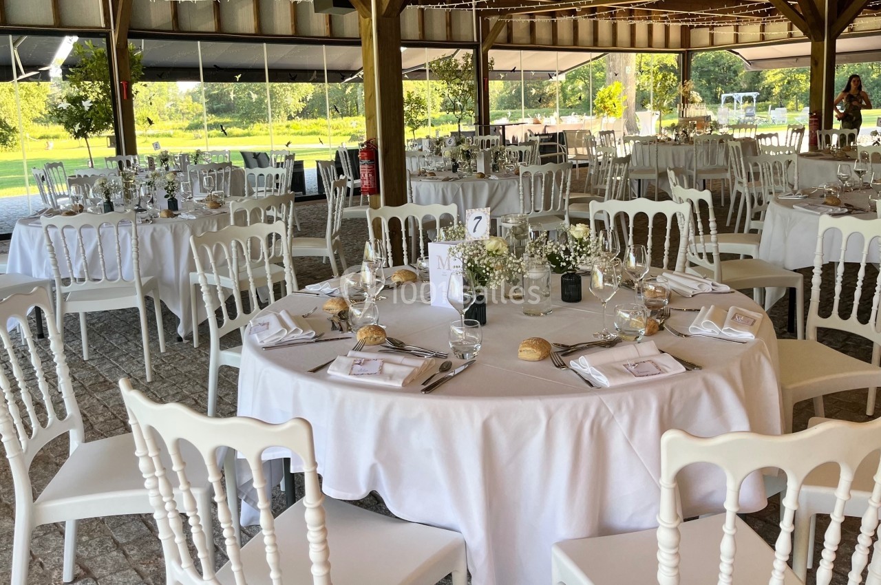 Location salle Cleppé (Loire) - L'Orangerie de Châtel #27 Salle de réception décorée avec des tables rondes dressées, nappes blanches, chaises élégantes et vue sur un jardin…