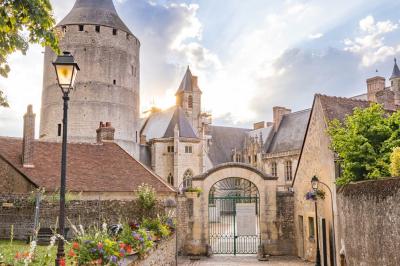 Salle de conférence vide avec des rangées de chaises noires, un écran de projection et des tables à l'avant.