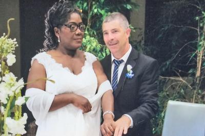 Table élégamment dressée avec nappes blanches, chemins de table verts, serviettes pliées et décorations florales.