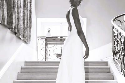 Table élégamment dressée avec nappes blanches, chemins de table verts, serviettes pliées et décorations florales.