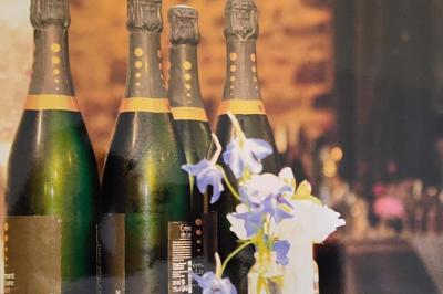 Table élégamment dressée avec nappes blanches, chemins de table verts, serviettes pliées et décorations florales.