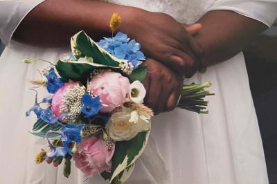 Table élégamment dressée avec nappes blanches, chemins de table verts, serviettes pliées et décorations florales.