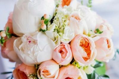 Table élégamment dressée avec nappes blanches, chemins de table verts, serviettes pliées et décorations florales.