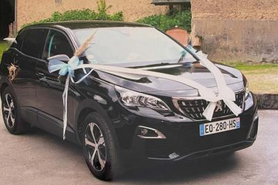 Table élégamment dressée avec nappes blanches, chemins de table verts, serviettes pliées et décorations florales.