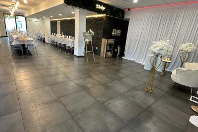 Miniature Location salle Le Blanc-Mesnil (Seine-Saint-Denis) - L'Horloge #18 Salle de réception moderne avec tables dressées, sol en carrelage gris, éclairage suspendu et décor floral.