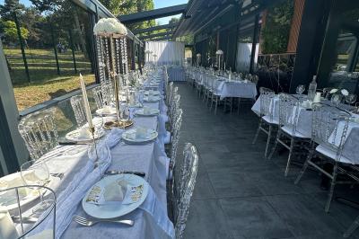 Miniature Location salle Le Blanc-Mesnil (Seine-Saint-Denis) - L'Horloge #15 Salle de réception moderne avec tables dressées, sol en carrelage gris, éclairage suspendu et décor floral.