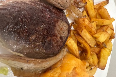 Miniature Location salle Le Blanc-Mesnil (Seine-Saint-Denis) - L'Horloge #9 Assiette contenant un steak grillé, une purée de pommes de terre, une salade verte et une sauce servie dans un ramequin.